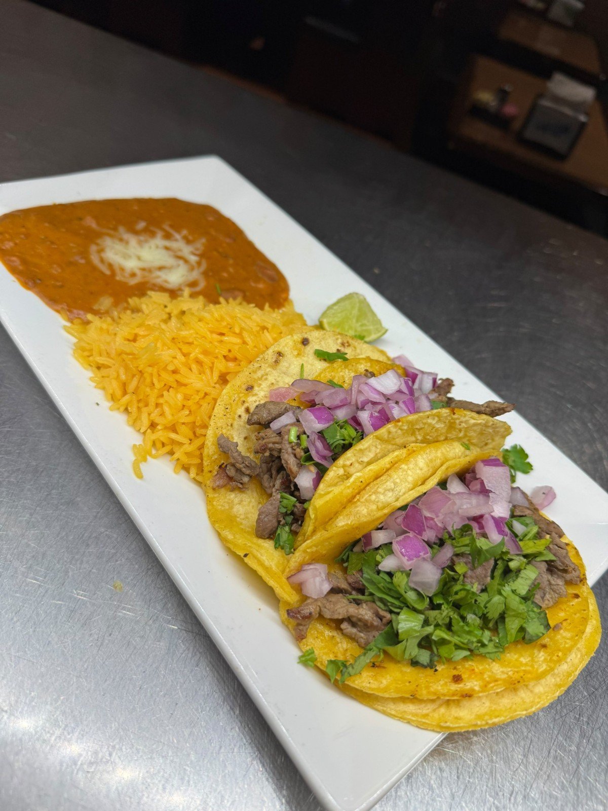 Two Mexican-style takos served with rice and beans